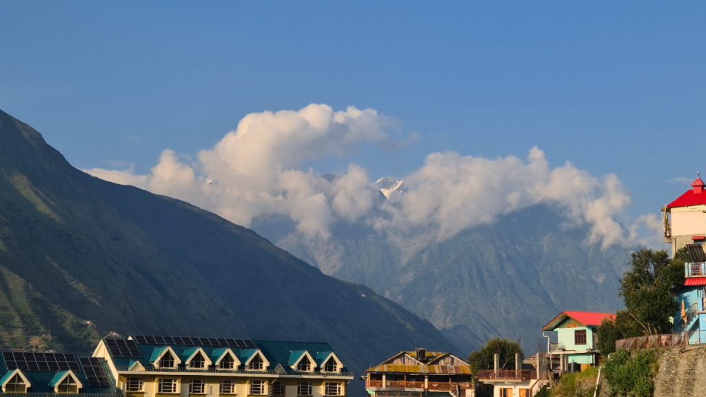 A majestic mountain peak rising into a bright blue sky filled with soft white clouds_