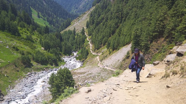 Walking through the Kugti trek with the beautiful Kugti Valley and river stretching across the Himalayan landscape.